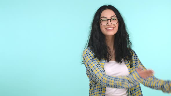 Attractive European Woman in Glasses with Long Wavy Hair Smiling and Demonstrating Product on Copy