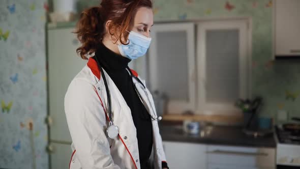 Young Doctor or Nurse with Home Visit Sits at Table