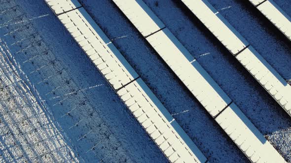 Top down view of a snow covered photovoltaic system. Aerial view of snow covered solar panels.