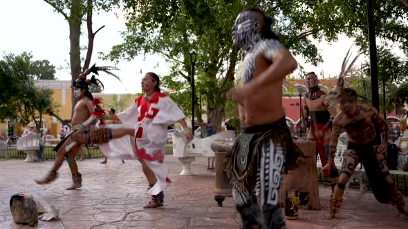 Mayan dancers performing to live drums, kicking legs into the air, outside in a park in Valladolid,