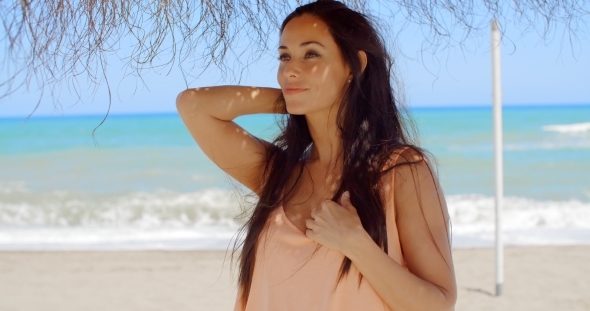 Thoughtful Woman Under Beach Umbrella Looking Afar