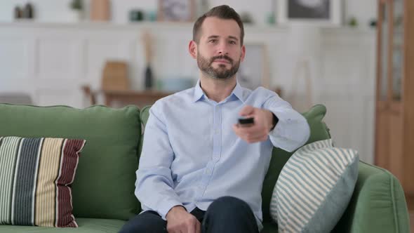 Young Man Watching Television in Bed 