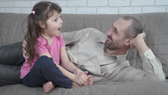 Сhild with dad on the couch.