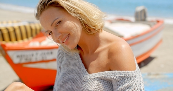 Smiling Woman Wearing Grey Sweater At Beach alt
