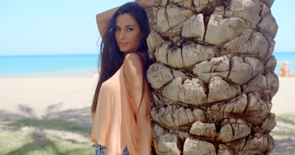 Pretty Woman Leaning Against Beach Palm Tree Trunk