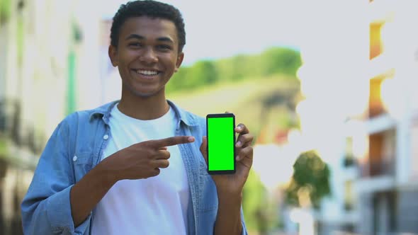 Smiling Teenager Holding Smartphone With Green Screen, Navigation Application