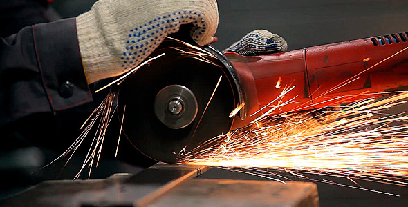 Worker Sawing Metal With a Circular Saw Sparks