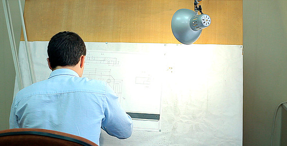 Man Draws a Technical Drawing on Drawing Board