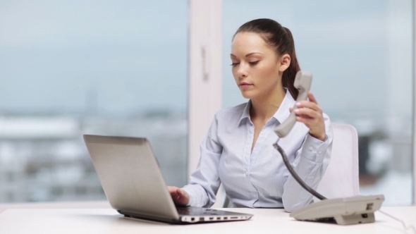 Serious Businesswoman With Laptop Calling On Phone