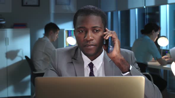 Close Up of AfricanAmerican Lawyer Having Late Phone Call with Client