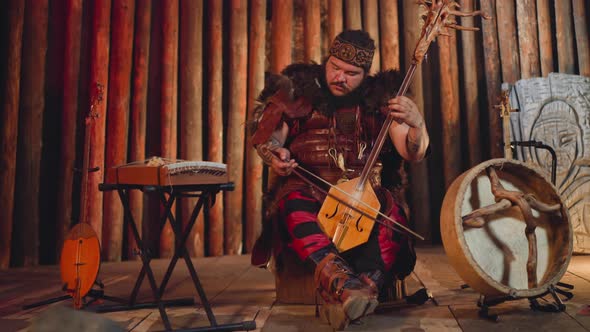 Musician in Traditional Suit Plays Igil at Folk Concert