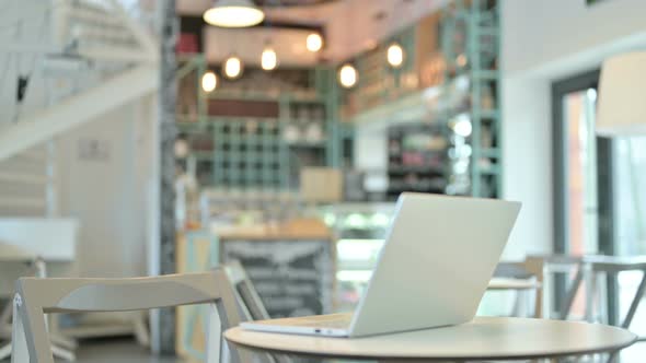 Young Woman Open Laptop on Top of Table in Cafe 