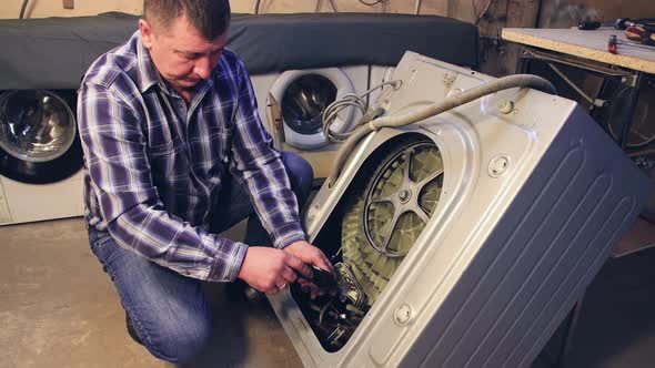 The Foreman Removes the Parts From the Washing Machine