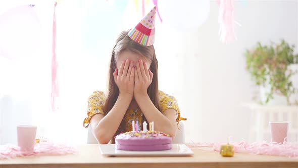 Caucasian Girl Is Dreamily Smiling and Looking at Birthday Rainbow Cake. Festive Colorful Background