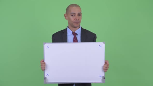 Stressed Bald Multi Ethnic Businessman Holding White Board