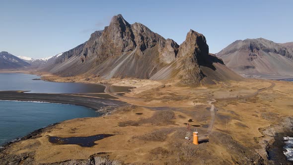 Big mountain with a orange lighthouse in the foreground