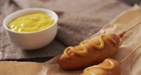 Video of corn dogs with dip on a wooden surface