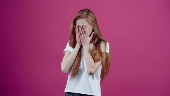 The Beautiful Sad Redhead Puts Her Palms to Her Face and Starts to Cry