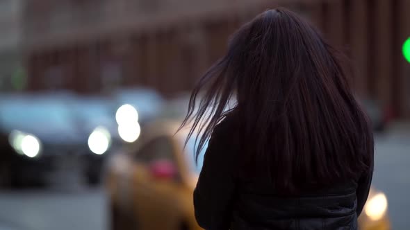 Portrait of a Brunette with Long Hair in a Knitted Sweater and a Dark Coat on a Cloudy Day