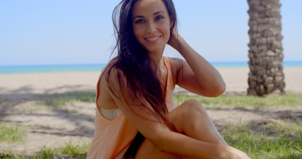 Attractive Woman Sitting At Grassy Beach Ground