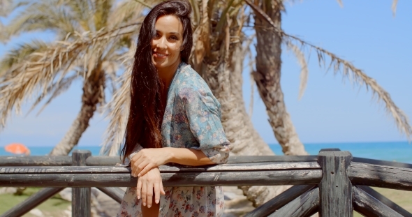 Pretty Young Woman Leaning On Railing At The Beach