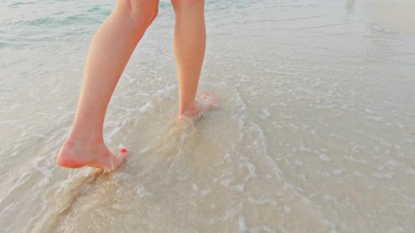 Legs Feet of Young Female Walking Sand Barefoot on the Beach