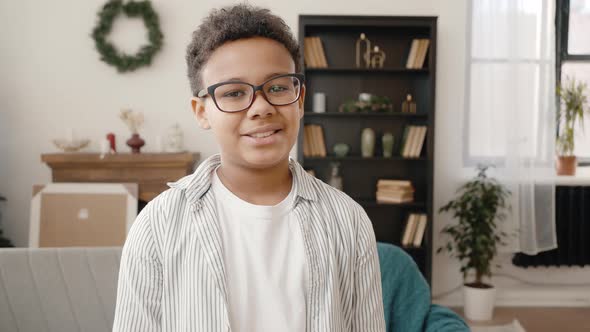 Cute African American Boy Wearing Eyeglasses Smiling to Camera Posing at Home with Christmas Tree