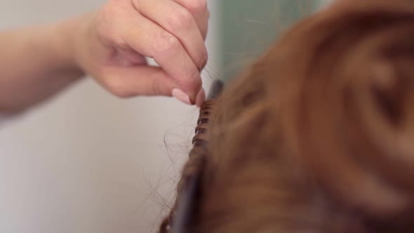 Close Up Shot of a Red Headed Woman Getting Her Hairs Curled in the Studio