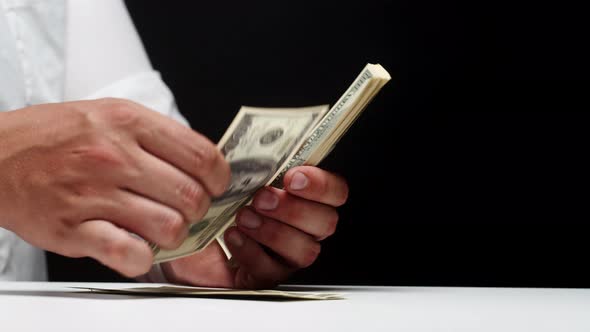 Counting American Hundred Dollar Banknotes on Black Background