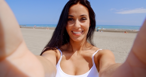 Young Brunette Woman Smiling While Making a Selfie