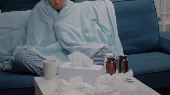 Woman with Fever Using Blanket and Pillow for Warmth