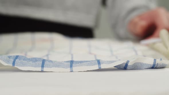 Woman Ironing Bath Towels on Iron Board Closeup