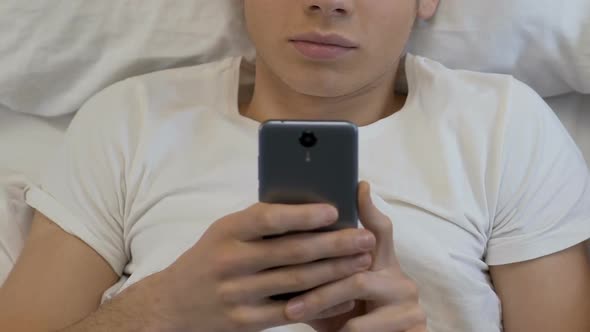 Teenage Boy Playing  Smartphone Games at Night, Downloading Applications