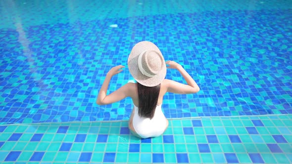 Young asian woman enjoy around outdoor swimming pool for leisure