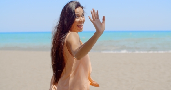 Happy Woman At The Beach Waving At The Camera