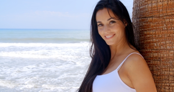 Woman At The Beach Leaning Against Tree Trunk