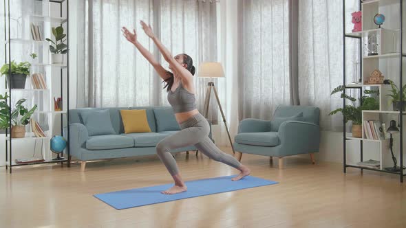 Young Asian Athletic Female In Sports Clothes Practicing Different Asana Poses On The Mat At Home