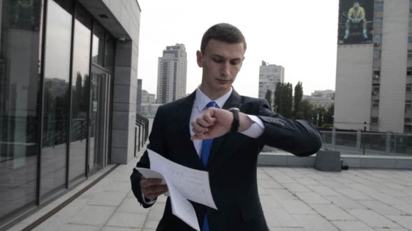 Businessman Walking and Checking Time