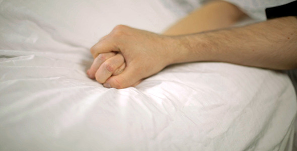 Man Sits and Holds Female Hospital Patient's Hand