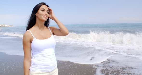 Woman Walking On Beach And Smiling At Camera