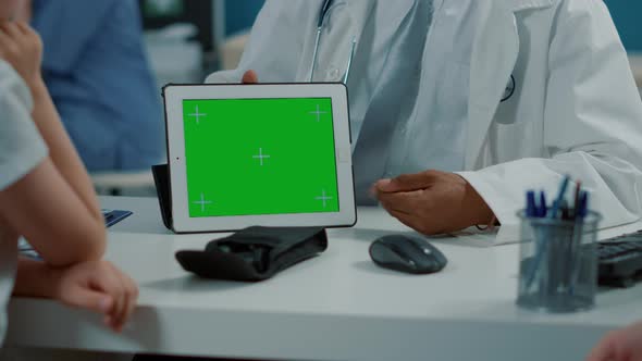 General Practitioner Holding Tablet with Horizontal Green Screen