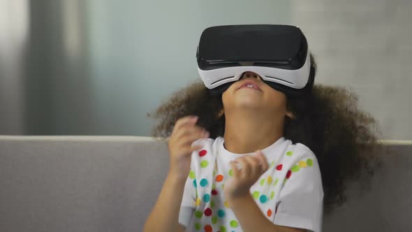 Funny African American Kid Wearing Virtual Reality Glasses and Playing Game