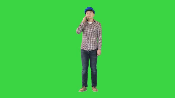 Asian Construction Worker Making a Call on a Green Screen Chroma Key