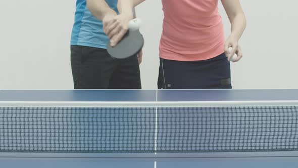 Unrecognizable Woman Showing Ball Serving To Man in Table Tennis. Female Caucasian Trainer Teaching