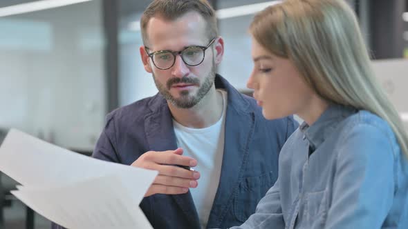 Male and Female Colleagues Having Argument Over Documents