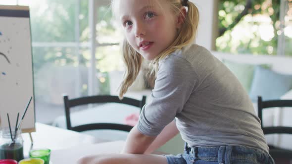 Side view of Caucasian girl painting at home