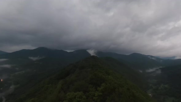 Aerial View Flying Above Lush Green Tropical Rain Forest Mountain with Rain Cloud Cover During the