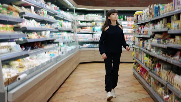 Independent Teenager in the Supermarket Passing By Food Sections