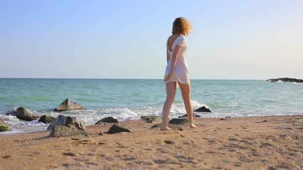 Young Beautiful Woman Walking at the Ocean Beach