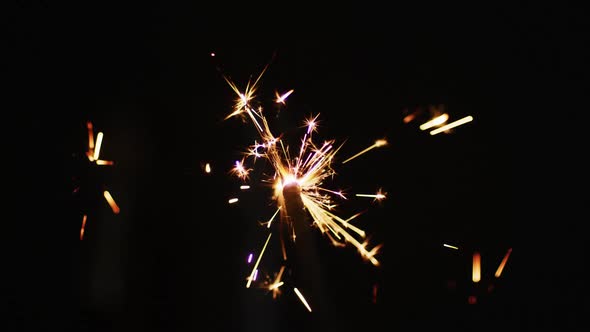 Lit party sparkler sparkling on black background